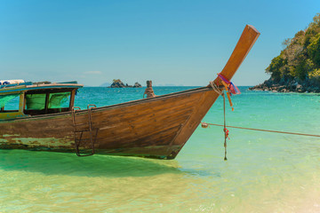 Traditional Thai longtail boat moored on exotic beach.