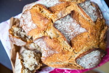 A warm, appetizing loaf of fresh brown bread with crispy crust