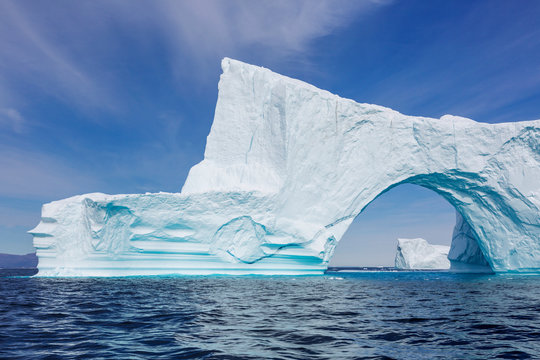 Majestic iceberg arch over sunny Atlantic Ocean Greenland