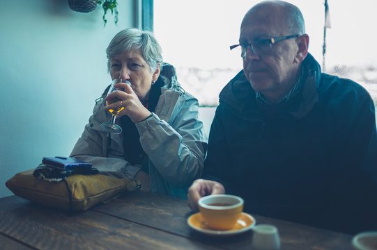 Retired couple drinking coffee and cider in cafe