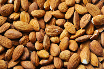 Background of big raw peeled almonds situated arbitrarily. Almonds background