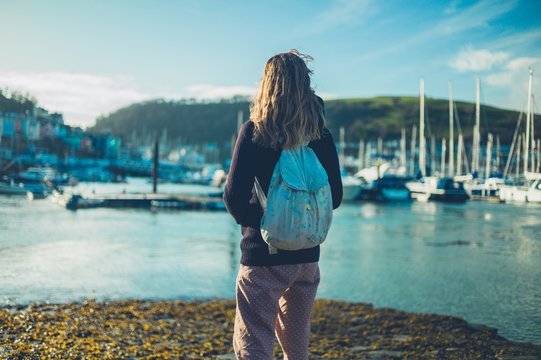 Young woman standing by the water in harbor
