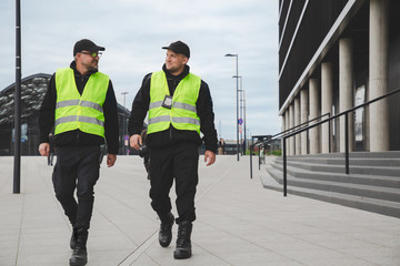 Two police officers in reflective vests patrol the streets of the city