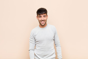 young handsome man with a big, friendly, carefree smile, looking positive, relaxed and happy,...