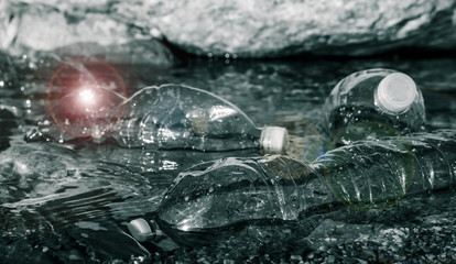 dramatic style image of floating plastic bottles on the riverbank