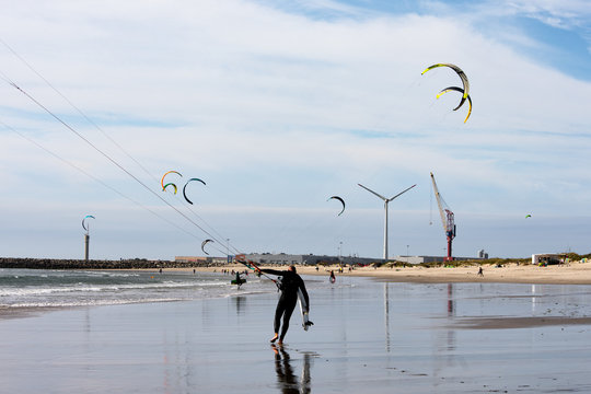 Kite Surf man handling gear, other kitesurfers in the background, in Praia do Cabedelo, Viana do Casteo, Minho, Portugal, Europe