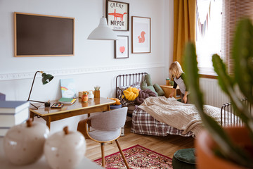 Trendy bedroom interior with bed and desk for school kid