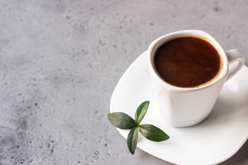 Coffee cup, coffee beans and milk jug on grey stone background. Copy space for text.