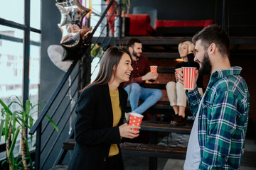 Break time in a modern office center charismatic and multiethnic workers drinking some fresh coffee and socializing with each other and smiling