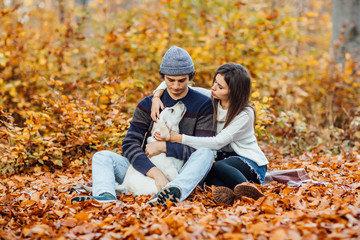 Beautiful young couple enjoying picnic time on the forest with golden labrador.