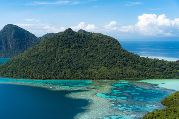Fototapeta premium Amazing tropical paradise islands from air with blue turquoise blue lagoon water and coral reef. Aerial view of Bohey Dulang island panorama. Hawaii, Philippines, French polynesia.