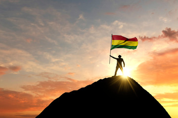 Bolivian flag being waved at the top of a mountain summit. 3D Rendering