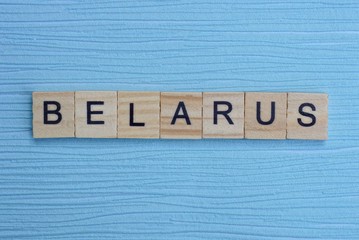  gray word belarus from small wooden letters on a blue table