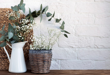vase with flowers and a photo frame at home on a wooden table.