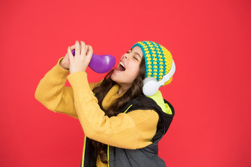 Explore the potential of your voice. Small child do vocal into microphone brush red background....