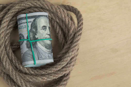 Hostage buyout concept image. Money dollars and rope