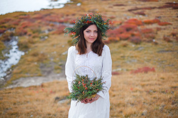 girl in a white dress walks on a background of mountains