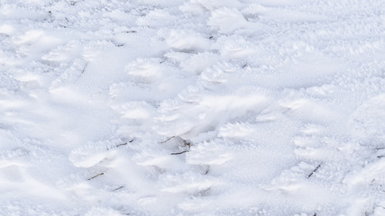 Fototapeta na wymiar Granular snow lies on the ground. Winter background