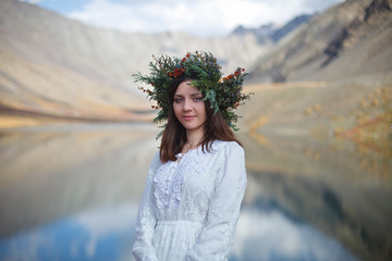 girl in a white dress walks on a background of mountains