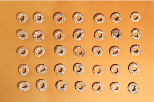 Bublik cookies pattern. Ring shaped roll cookies on orange background.. © vaitekune