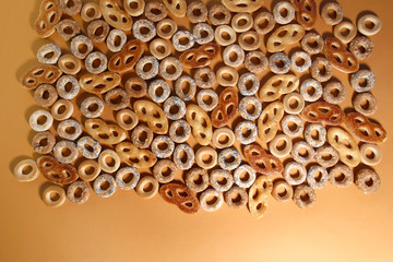 Bublik cookies pattern with copy space, top view. Ring shaped roll cookies with different glaze on orange background..