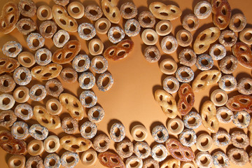 Bublik cookies pattern with copy space, top view. Ring shaped roll cookies with different glaze on orange background..