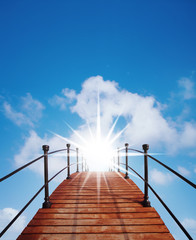 Fototapeta premium eine Holzbrücke führt zum Himmel