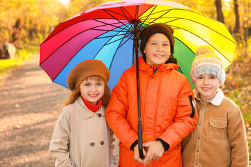 Cute little children with umbrella in autumn park