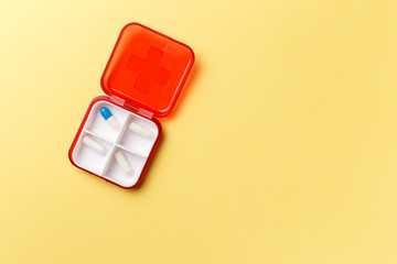 Dose pill box with medical pills on yellow background. Top view. Flat lay. Copy space. Pharmaceutical medicine pills, tablets and capsules. Medicine concepts. Trendy pastel color