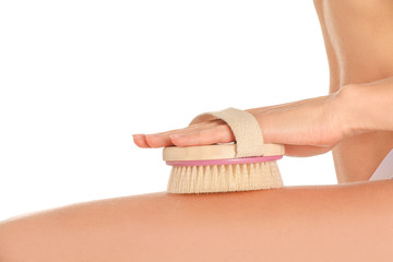 Beautiful young woman with massage brush on white background, closeup
