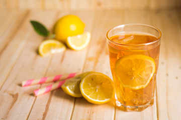 Glasses of ice tea with lemon slices on wooden background