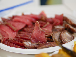 Cured meat closeup. Cut into pieces and laid out on a plate.