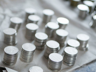 Silver coins close up. Counting savings. Tax rate. Production costs. Distribution of finance. Laid out by a column