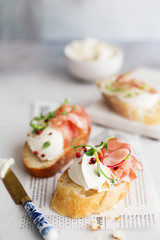 Bruschetta with prosciutto and cream cheese. Bread with smoked bacon and cream cheese. Toasted bread slice with meat and cream cheese