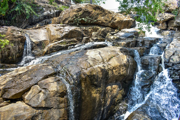 awesome view of waterfall passing through a mountain big rock near by water reservoir.