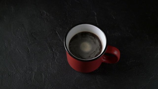 Cinemagrah, red mug with coffee on black background