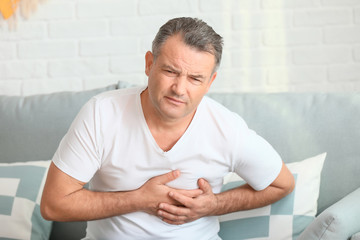 Fototapeta premium Mature man suffering from heart attack at home