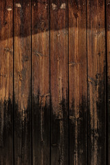 Spanish wooden door with dark and orange woods and a wrought metal horseshoe handle