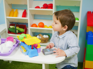A child plays with toys at home. Little child plays with toys in kindergarten.