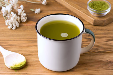 traditional, healthy drink green matcha tea on a wooden table in a mug. rustic concept