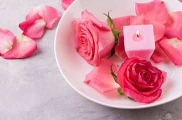 pink petals of roses and burning candles