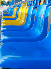 Obraz premium empty rows blue and yellow plastic seats on stadium