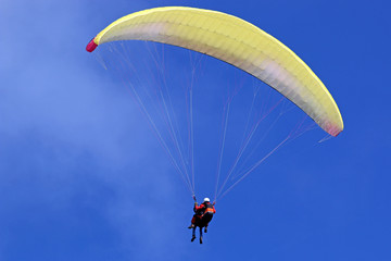 Tandem Paraglider flying wing in a blue sky