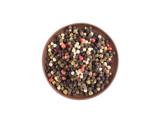 Bunch of color pepper in clay plate isolated on white background. Indian cuisine, ayurveda, naturopathy concept