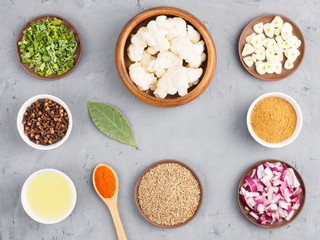 Ingredients for cooking cauliflower: butter, onion, cumin (jeera), red chili pepper, masala, bay leaves, green herb, cloves, garlic. Healthy eating concept