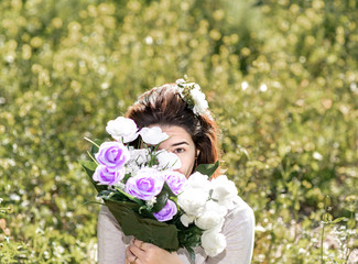 Chica escondida tras ramo de flores