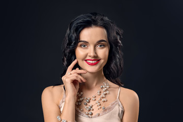 Young woman with beautiful jewelry on dark background