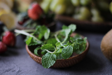 Photo of fresh mint leaves in a bowl. Mint and strawberry. Ingredients for summer cocktails and lemonade. Herb. Still life photography. Image