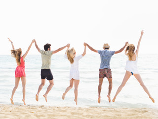 Obraz premium Group of friends jumping on the beach
