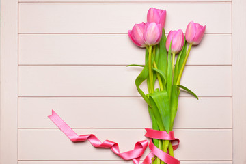 Beautiful tulip flowers on white wooden background